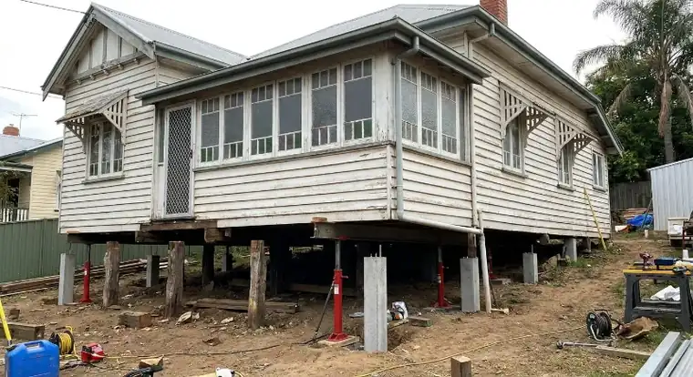 New concrete stumps set in gravel beneath a house with the old stumps removed