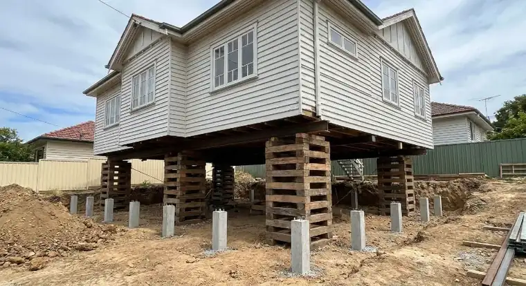 A floor frame supported on jacks during a controlled re-levelling